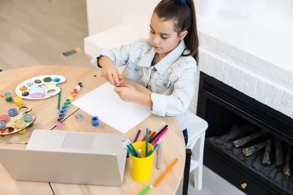 Ciddi küçük kız el yazısı çalışması evde dizüstü bilgisayar kullanarak, şirin mutlu küçük çocuk İnternet dersi ya da ders alıyor. — Stok fotoğraf