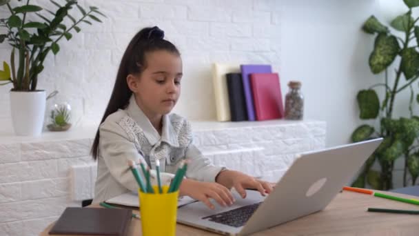 Παιδιά, εκπαίδευση και μακρινή έννοια μάθησης, κοριτσάκι φοιτητής με φορητό υπολογιστή στο σπίτι — Αρχείο Βίντεο