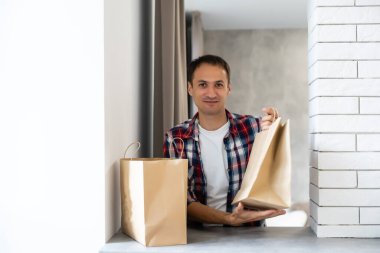 dağıtım, posta ve insan konsepti - tek kullanımlık kağıt torba içinde müşteriye yemek getiren mutlu bir adam