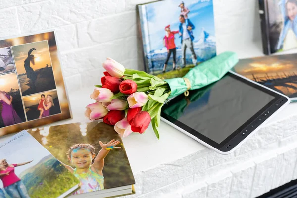 Livro de fotos e flores tulipas como um presente de férias mentira na prateleira — Fotografia de Stock