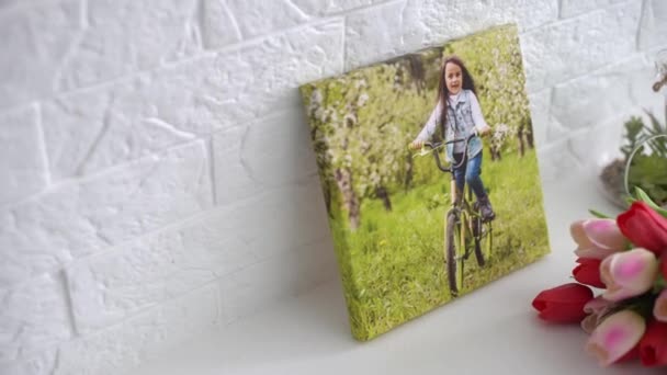 活跃的小女孩和鲜花郁金香作为节日礼物的照片画布放在架子上 — 图库视频影像
