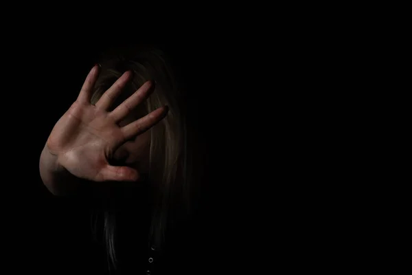 Mujer con la mano levantada sobre fondo negro —  Fotos de Stock