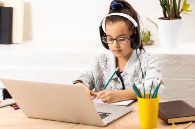 Masada dizüstü bilgisayarı olan kulaklıklı mutlu kız.