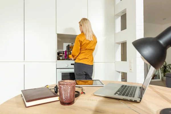 Портрет женщины, работающей с ноутбуком на яркой кухне. Коронавирус Ковид-19. Социальное дистанцирование — стоковое фото