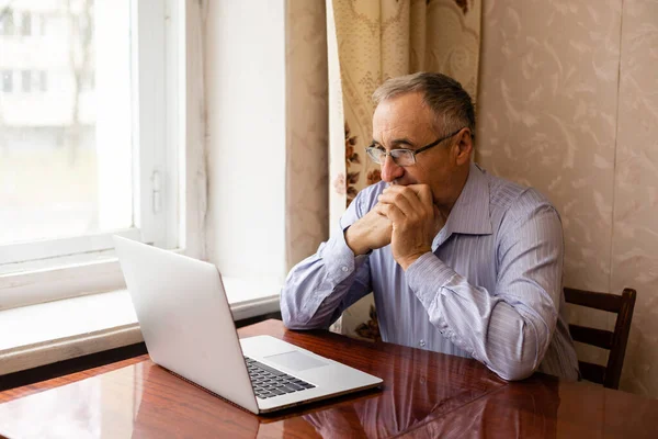 Senior working on a laptop at home — Stock Photo, Image