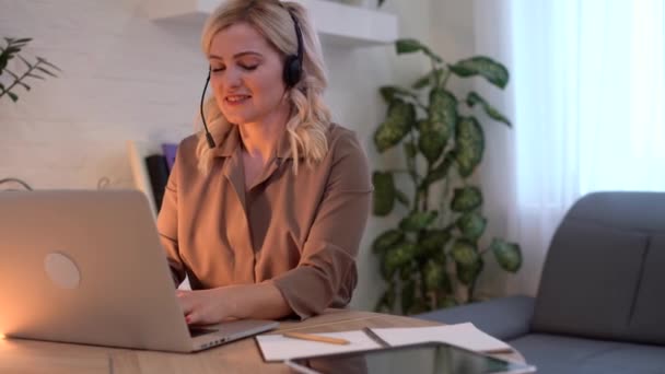 オフィスのラップトップで同僚とビデオチャットをしている女性 — ストック動画