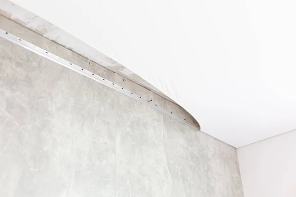 Fijar el marco de metal para el techo tensado con un destornillador eléctrico. Reparación, construcción, concepto DIY. — Foto de Stock