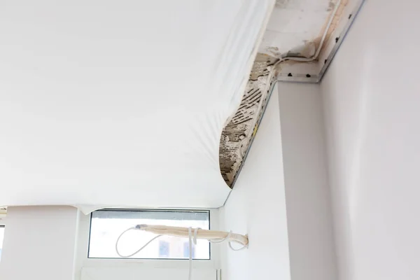 Fijar el marco de metal para el techo tensado con un destornillador eléctrico. Reparación, construcción, concepto DIY. — Foto de Stock