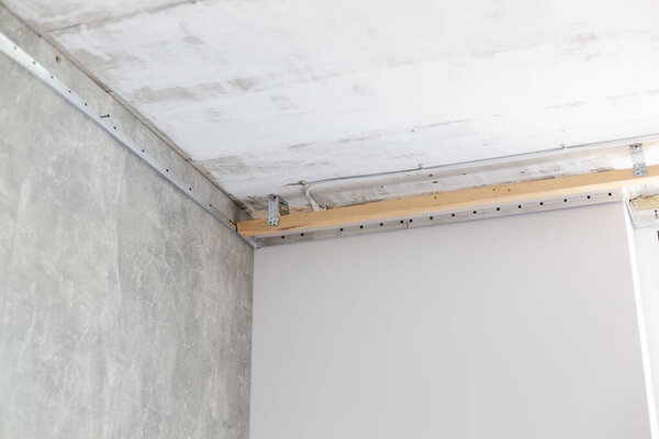 fix the metal frame for the stretch ceiling with an electric screwdriver. Repair, construction, DIY concept.