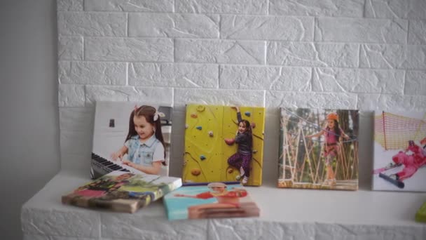 Выставка фотографий, фотополотен, активная маленькая девочка. — стоковое видео