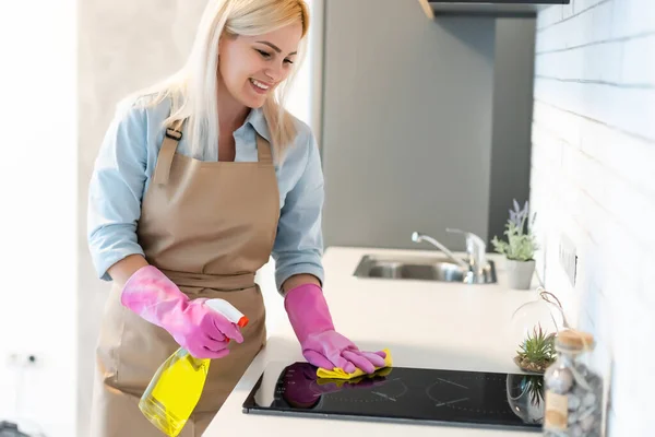 Joven mujer limpieza gabinetes de cocina —  Fotos de Stock