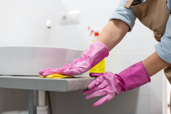 Cleaning - cleaning bathroom sink with spray detergent - housework, spring cleaning concept