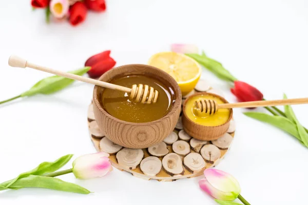 Miele in una ciotola di legno e fiori tulipani donna giorno, — Foto Stock