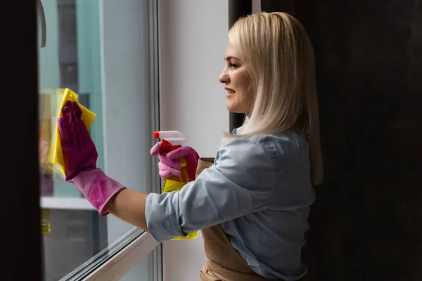 Kadın apartmanın camını temizliyor. — Stok fotoğraf