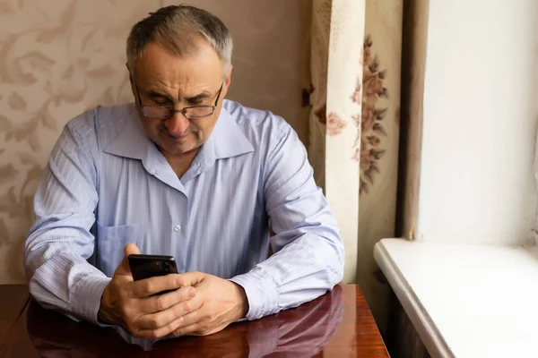 Teknoloji, insanlar, yaşam tarzı ve iletişim konsepti - telefon numarası çeviren ve evde akıllı telefondan mesaj atan mutlu kıdemli adam — Stok fotoğraf