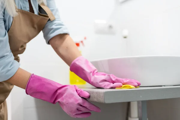 Huishouden en huiselijke levensstijl: vrouw doet klusjes in de badkamer thuis, wasbak schoonmaken en kraan met spuitwasmiddel — Stockfoto