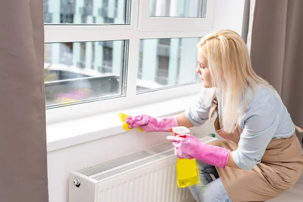 Beautiful young woman makes cleaning the house. Girl rubs dust. — Stock Photo, Image