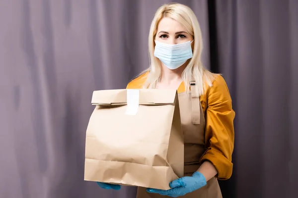 Caucasian young pretty woman, delivery worker medical mask. Female beautiful courier — Stock Photo, Image