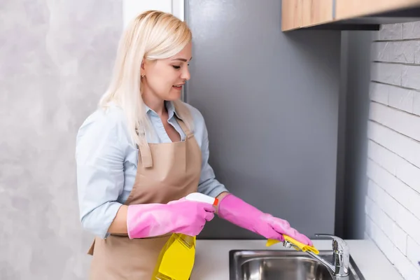 Fiatal nő Takarítás Konyha szekrények takarítás a konyhában — Stock Fotó