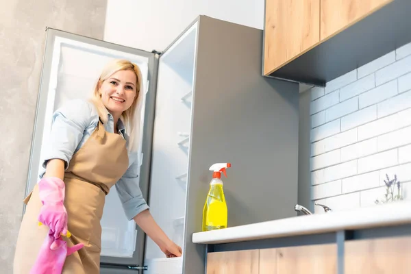 Ung kvinna rengöring kök skåp — Stockfoto