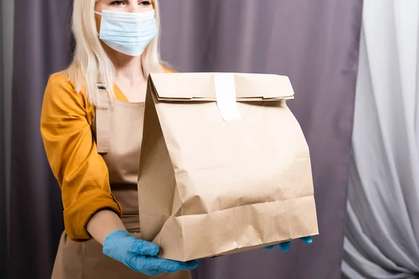 Mulher bonita jovem caucasiana, assistente de parto máscara médica. Mulher bela mensageiro — Fotografia de Stock