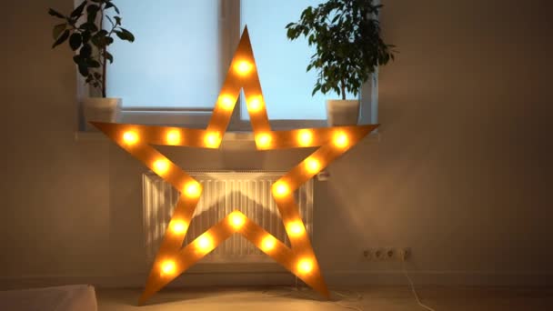 Close-up van enkele elektrisch verlichte ster met warm gele lichten. Sterrenverlichting decoraties thuis, Kerstmis en Nieuwjaar feest thuis — Stockvideo