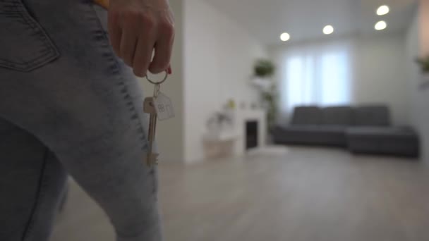 Een vrouw loopt een nieuw appartement binnen. Leeg appartement. — Stockvideo