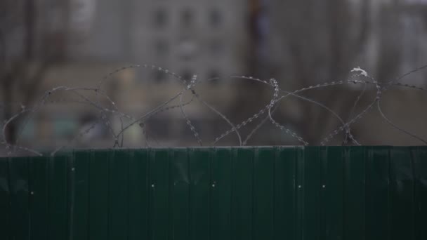 Höga fängelsemurar med taggtråd, avlägsna stakettrådar och vakttornet syns på avstånd — Stockvideo