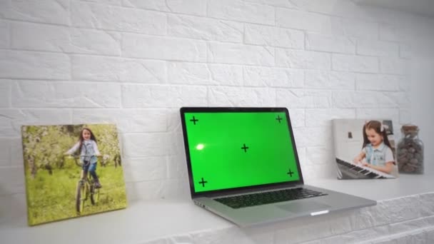 Зелений екран ноутбук комп'ютер сидить на домашньому робочому столі поруч з настільною лампою . — стокове відео