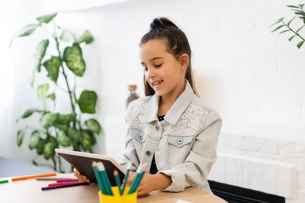 Mensen, kinderen en onderwijs concept - meisje met tablet pc computer schrijven thuis — Stockfoto