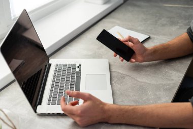 Evden dizüstü bilgisayarda çalışan mutlu genç tasarımcı, serbest konsept.