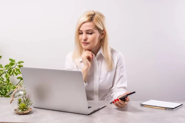 Retrato de una joven sonriente usando laptop y smartphone —  Fotos de Stock