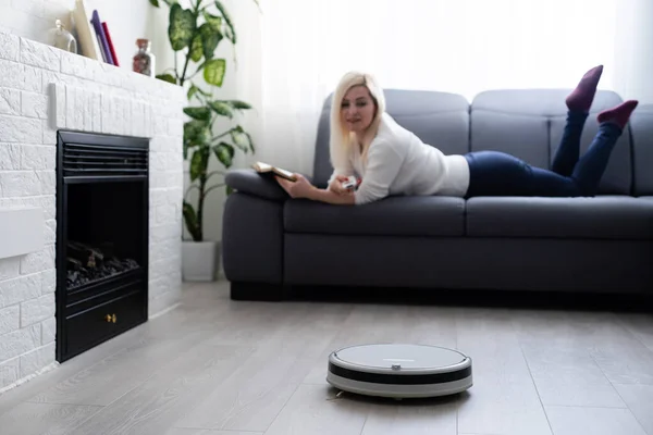 Lidé, domácí práce a technologie koncept - šťastná žena a robot vysavač doma — Stock fotografie