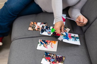 Yaşlı bir kadın torunlarının fotoğrafına bakıyor.