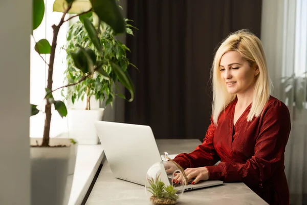 Mooie jonge vrouw werken op haar laptop in haar kantoor. — Stockfoto