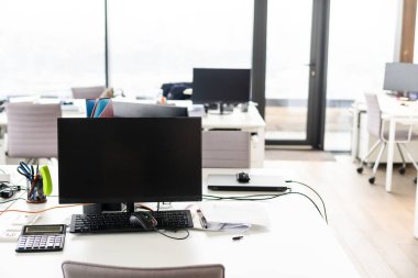 Bilgisayarı ve ahşap masasında akıllı telefonu olan bir ofis.