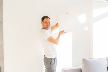 Tuvali olan bir adam. Fotoğraf Modeli. Adamın elinde tuval var. Tablo tasarımı için.