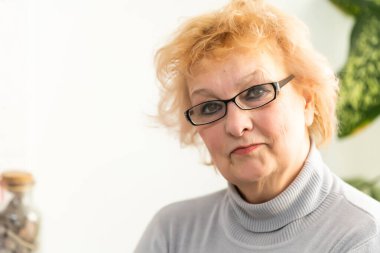 Fotoğraf makinesine bakıp konuşan olgun bir kadın. Büyükannem internetten akrabasıyla sohbet ediyor. Video görüşmesi yapıyor. Orta yaşlı blogcu vlog 'u kaydediyor.