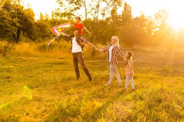 Mutlu aile tarlada yürüyor ve gün batımını seyrediyor.