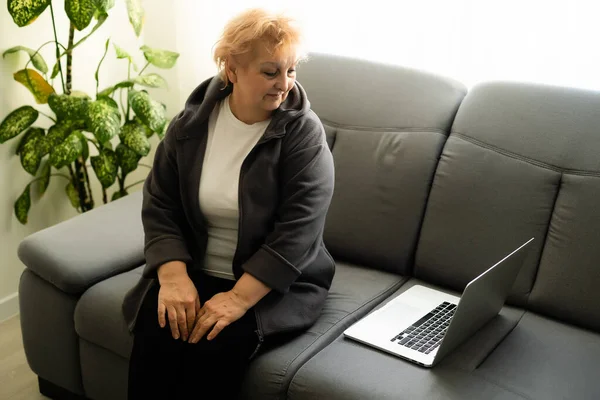 Äldre kvinna tittar på laptop. videokommunikation online med släktingar — Stockfoto