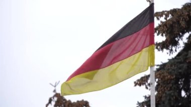 Almanya bayrağı. Kumaş bayrakları bulutlu bir günde rüzgarda dalgalanıyor.