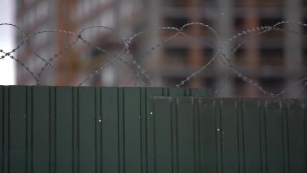 Hoge gevangenismuren met prikkeldraad, de verre hekdraden en de wachttoren is zichtbaar op de verte — Stockvideo