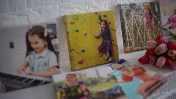 Photo canvases of active little girl and flowers tulips as a holiday gift lie on the shelf — Stock Video