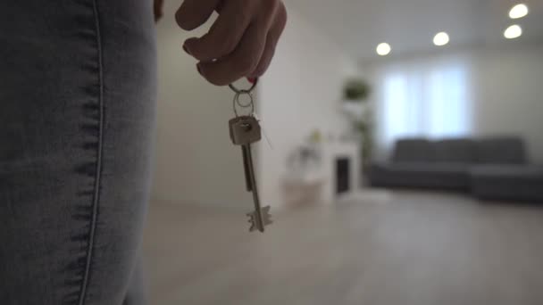 Moving in new apartment, woman with keys walks into her new flat, empty white rooms, new home construction. — Stock Video