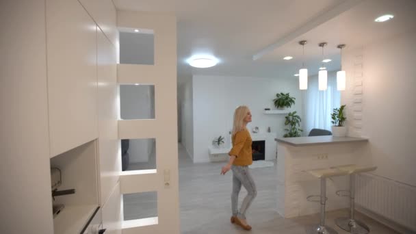 Una mujer entrando en un apartamento nuevo. Apartamento vacío. — Vídeos de Stock