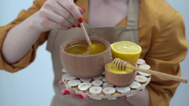 Cropped view of woman mixing honey with lemon on white background. — Stock Video