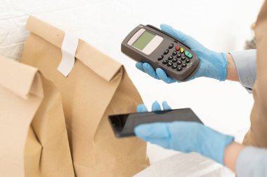 Satıcı ödeme postu terminalini tutuyor. Metin için boşluk