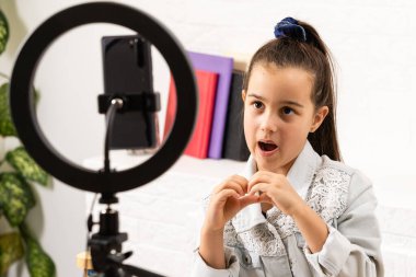 Video yayını. Sevimli çocuk yeni teknoloji öğreniyor. Cep telefonu kullanan küçük bir kız, akıllı telefon. Güzel cep telefonu teknolojisi kullanıcısı. Mobil aygıtta video izleniyor.