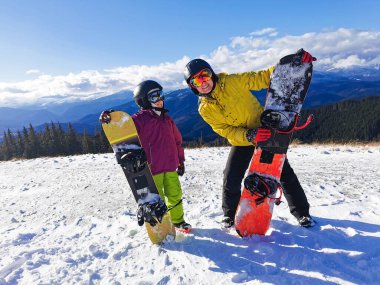 Dağlarda kış tatili yapan snowboardcu ailesi.
