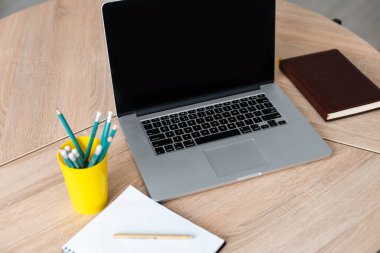 Evde dizüstü bilgisayarı, not defteri ve kalemleri olan işyeri